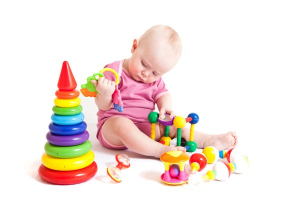 پرتره دختر بچه ناز در حال بازی کردن اسباب بازی جدا شده روی سفید