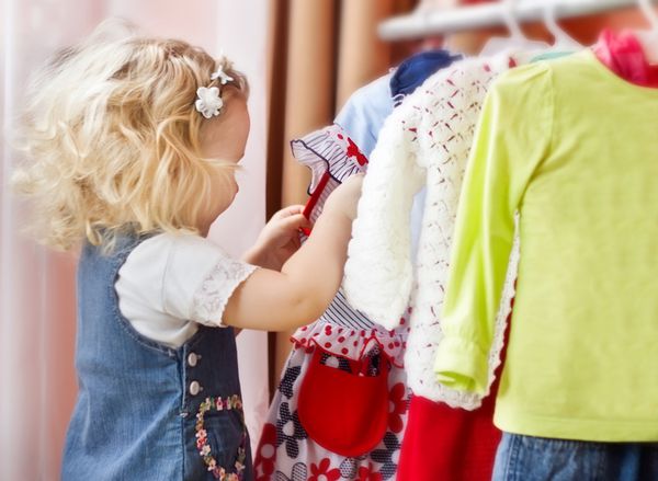 دختر کوچولوی دوست داشتنی در حال انتخاب لباس
