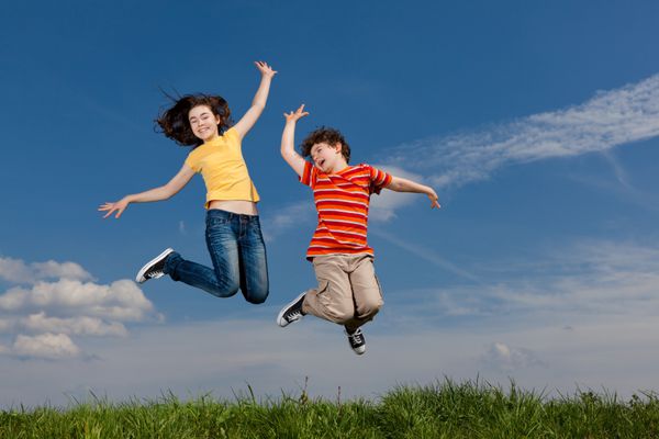 دختر و پسر در حال پریدن دویدن در فضای باز