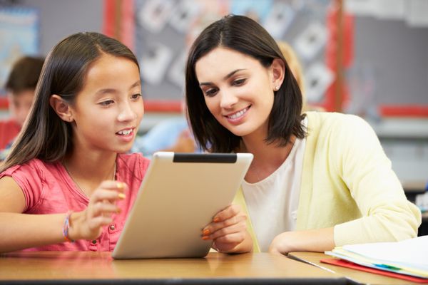 دانش آموزان در کلاس با استفاده از تبلت دیجیتال با معلم