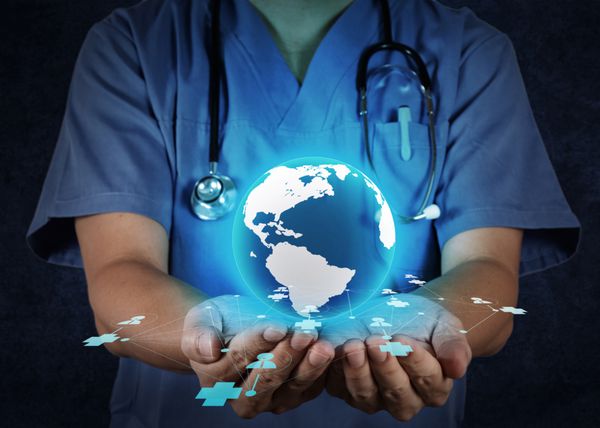 دکتر پزشکی که یک کره جهانی را در دستان خود به عنوان مفهوم شبکه پزشکی در دست دارد