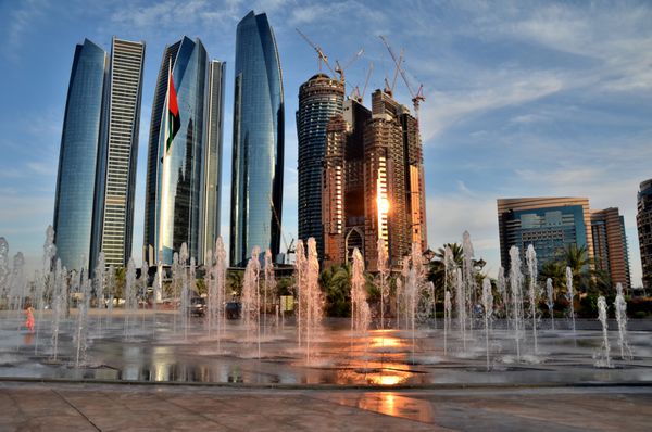 فواره ای در پس زمینه آسمان خراش ها در ابوظبی امارات متحده عربی