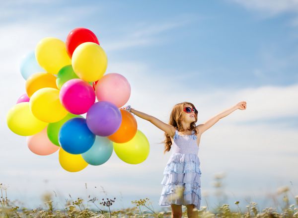 تعطیلات تابستانی جشن خانواده کودکان و مفهوم مردم - دختر شاد با بادکنک های رنگارنگ