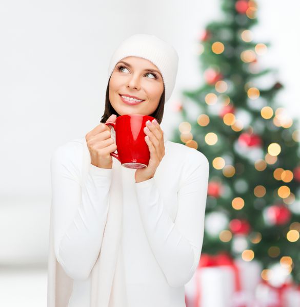 زمستان مردم شادی نوشیدنی و مفهوم غذا - زن با کلاه با لیوان چای یا قهوه قرمز