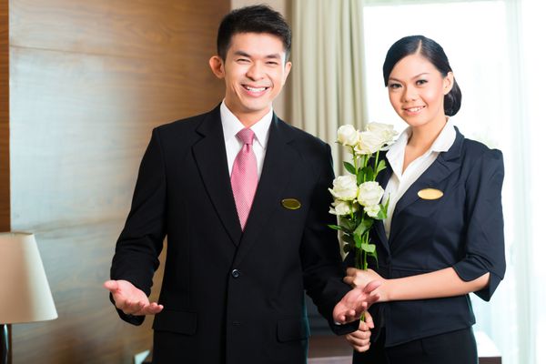 مدیر هتل یا مدیر و سرپرست هتل از مهمانان VIP با گل رز در هنگام ورود به هتل مجلل یا بزرگ استقبال می کنند