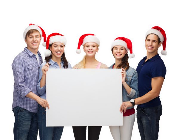 آموزش تبلیغات فروش کریسمس و مفهوم مردم - گروهی از دانش آموزان خندان با کلاه کمکی بابا نوئل با تخته سفید خالی