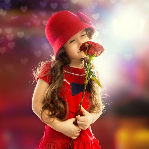 مردم مفهوم شادی دختر کوچولوی شاد با گل رز با لباس قرمز