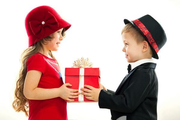 پسر کوچکی که به دختر هدیه می دهد برای تولد روز ولنتاین تولد یا تعطیلات دیگر ارائه دهید جدا شده در زمینه سفید