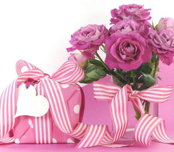 هدیه و گل رز زیبا در زمینه صورتی و سفید با فضای کپی برای متن شما در اینجا برای روز مادر روز جهانی زن تولد زن عروسی یا هدیه عاشقانه عاشقانه