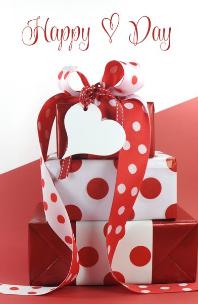 هدایایی تزئین شده با نقطه پولکا روی پس‌زمینه قرمز و سفید با متن نمونه یا فضای کپی برای ولنتاین روز مادر روز جهانی زن تولد عروسی رویداد عاشقانه یا تعطیلات عاشقانه