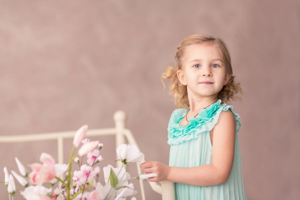 دختر کوچولوی ناز در لباس مد با گل های بهاری