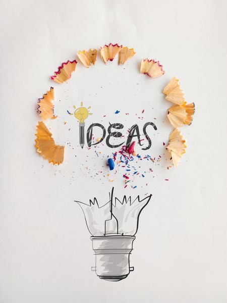 طراحی کلمه لامپ دستی طرح ایده با گرد و غبار اره مدادی روی پس زمینه کاغذ به عنوان مفهوم خلاقانه