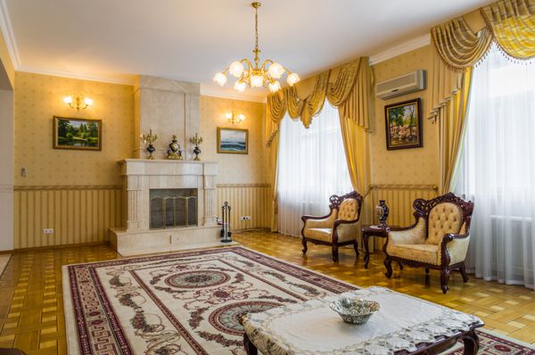 اتاق نشیمن کلاسیک داخلی زرد با فرش شومینه
