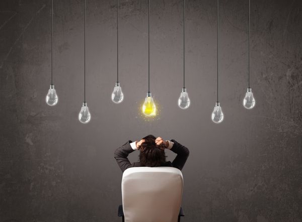 مرد تجاری در مقابل ایده روشن مفهوم لامپ