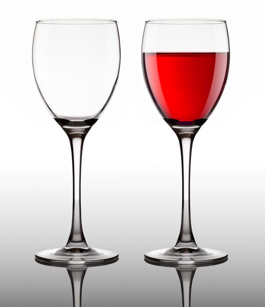 جام شیشه ای خالی و پر با شراب قرمز در زمینه خاکستری