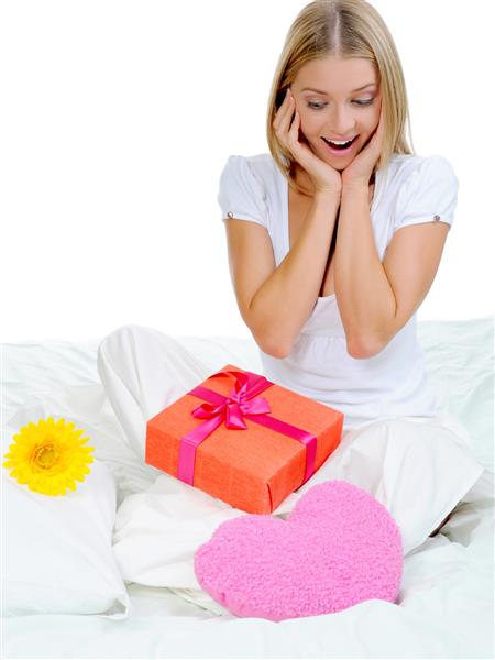 زن جوان با جعبه هدیه در تخت جدا شده در زمینه سفید