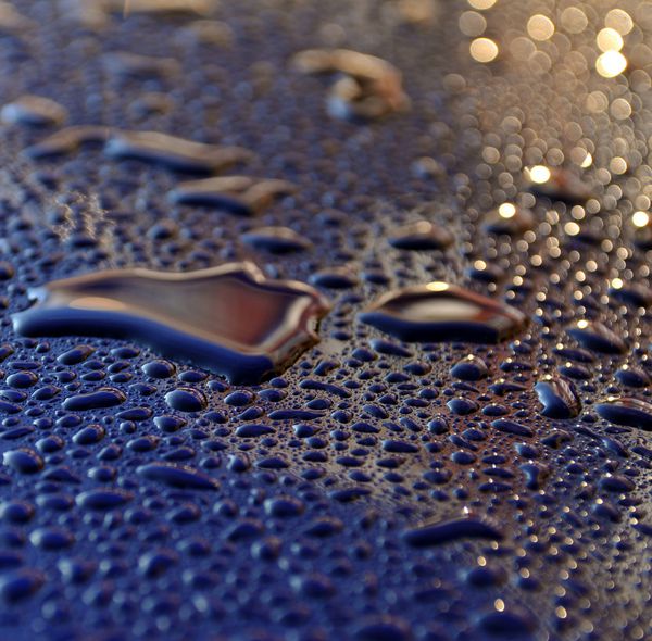 قطرات آب پس از باران شدید در طلوع آفتاب صبح در رنگ ماشین متالیک