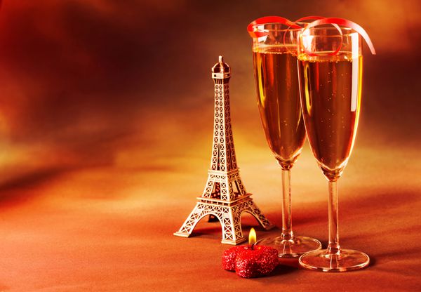 عکس دو لیوان شراب تزئین شده با روبان قرمز شمع قلبی شکل و برج ایفل کوچک طبیعت بی جان روز ولنتاین در پاریس پس زمینه گرانج تیره مفهوم عشق و عاشقانه