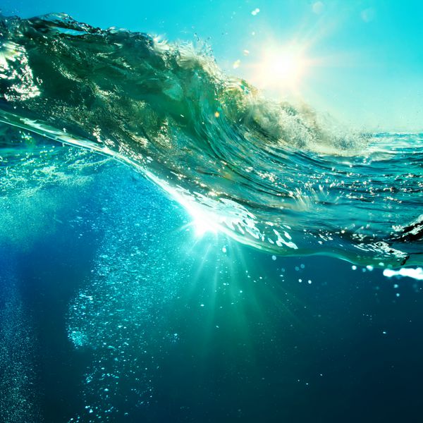 موج ناهموار اقیانوسی که در زمان غروب خورشید شکسته می شود