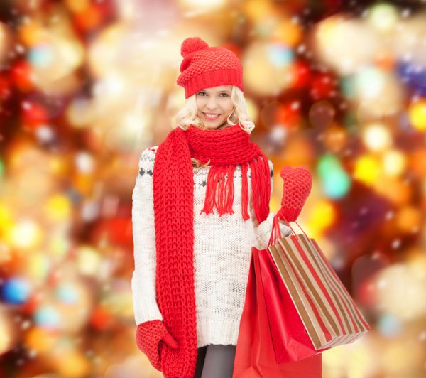 تعطیلات فروش مفهوم کریسمس - دختر نوجوان زیبا در لباس های زمستانی با کیف خرید