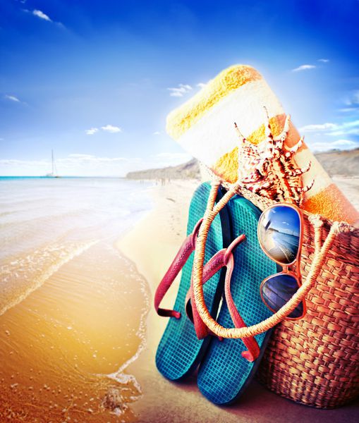 لوازم جانبی تابستانی مایو عینک آفتابی کیف و دمپایی نمای نزدیک از کیف ساحل تابستانی و کلاه حصیری در ساحل شنی