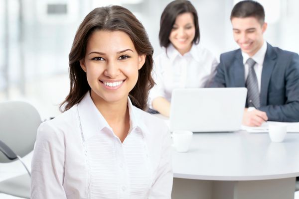 زن تجاری موفقی که با تیمش در دفتر نشسته است