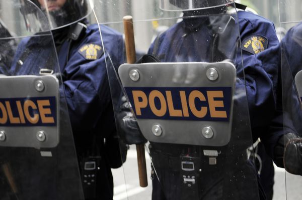 تورنتو-26 ژوئن افسران پلیس ضد شورش از محیط رویداد اصلی در جریان اعتراض G20 در 26 ژوئن 2010 در تورنتو کانادا محافظت می کنند
