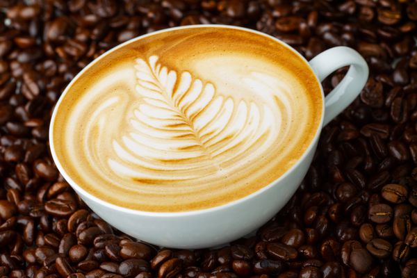 لاته آرت قهوه در پس زمینه دانه های قهوه