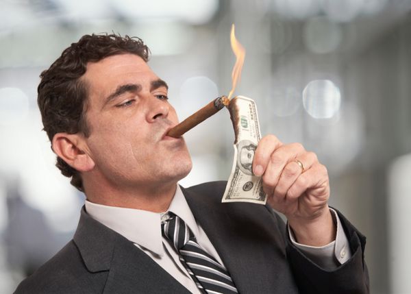 تاجر ثروتمندی که سیگار را با اسکناس 100 دلاری روشن می کند