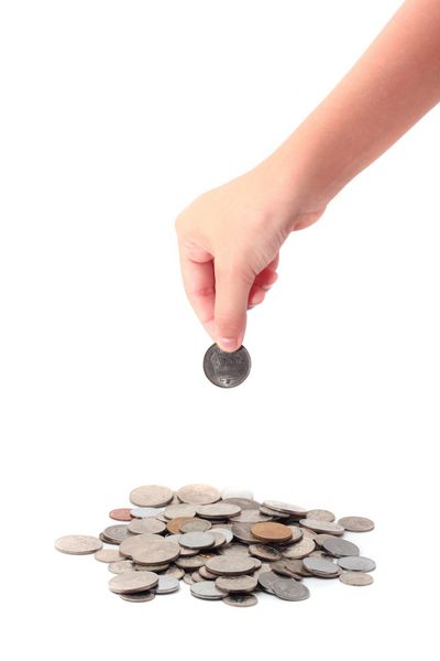 مفهوم آموزش مالی با دست های کودک در حال گذاشتن سکه های جدا شده در پس زمینه سفید