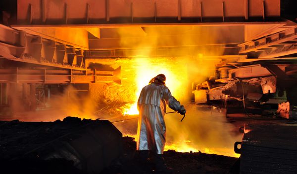کارگر با فولاد داغ در کارخانه
