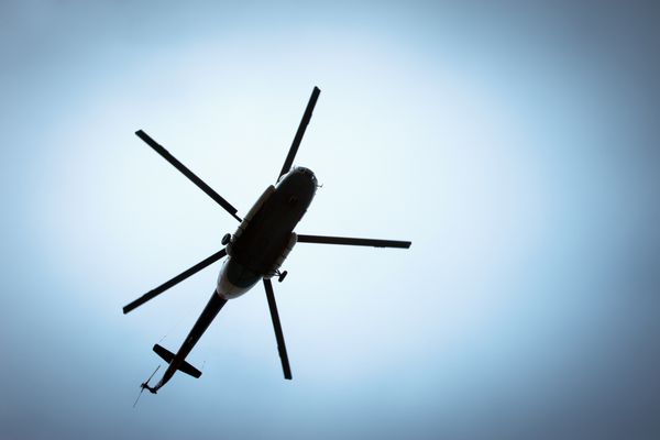 هلیکوپتر در حال پرواز در برابر آسمان آبی