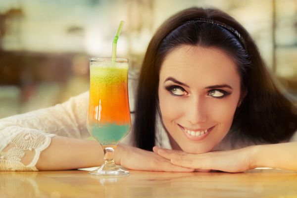 زن جوان با نوشیدنی کوکتل رنگارنگ بیرون - زن زیبا در حال لذت بردن از نوشیدنی کوکتل در یک روز آفتابی