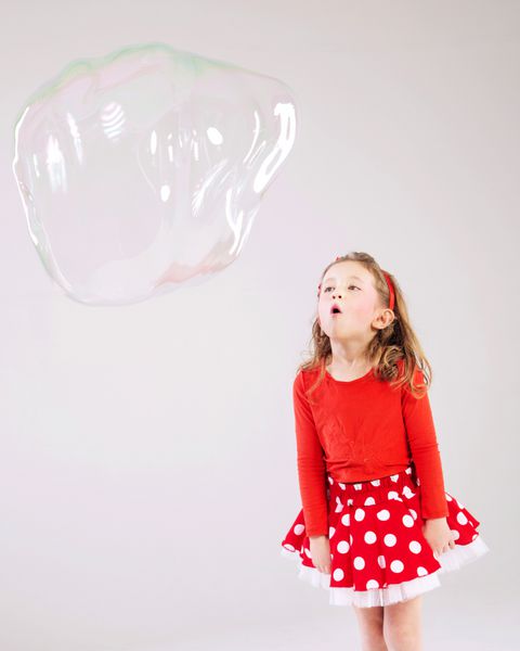 دختر بچه دوست داشتنی در حال بازی با حباب های صابون