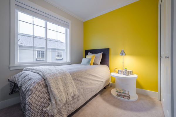 فضای داخلی اتاق خواب مدرن زرد در یک خانه لوکس