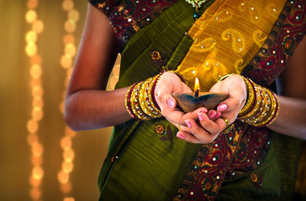 عکس دیوالی یا دیپاوالی با زن چراغ روغنی در دست در جشنواره نور