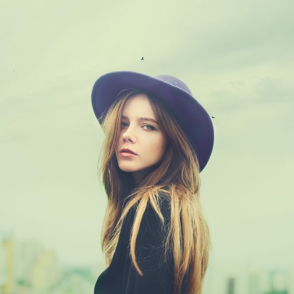 پرتره یک دختر جوان زیبا با کلاه