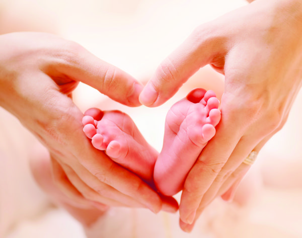 پای کودک در دستان مادر پاهای نوزاد تازه متولد شده کوچک روی دست های زنانه به شکل نزدیک مامان و فرزندش مفهوم خانواده شاد تصویر مفهومی زیبا از زایمان