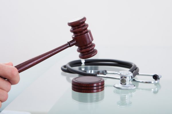 قصور و گوشی پزشکی قضات در تصویری مفهومی از قضاوت در یک ادعای قصور پزشکی