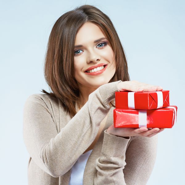 زن جوان جعبه هدیه قرمز در دست دارد پرتره