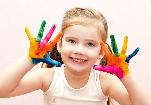 دختر کوچولوی خندان و بامزه با دستان جدا شده با رنگ