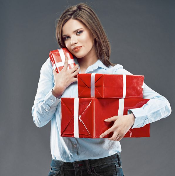 زن جوان جعبه هدیه قرمز در دست دارد استودیو ایزوله شده روی خاکستری