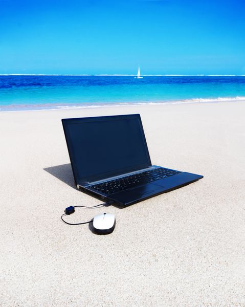 لپ تاپ با ماوس در ساحل شنی