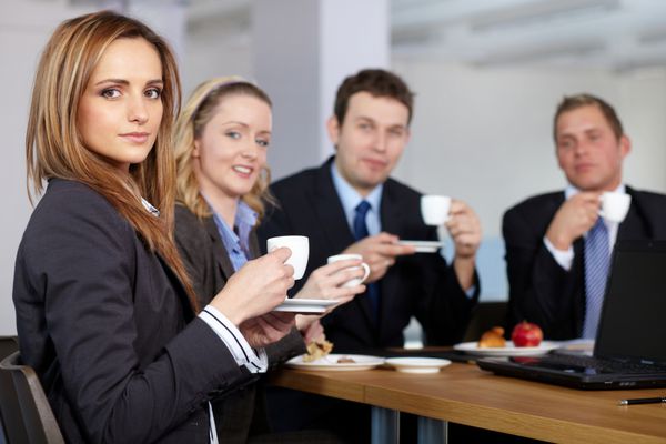 تیم تجاری که در طول جلسه خود یک استراحت قهوه دارند همه فنجان های کوچک قهوه در دست دارند
