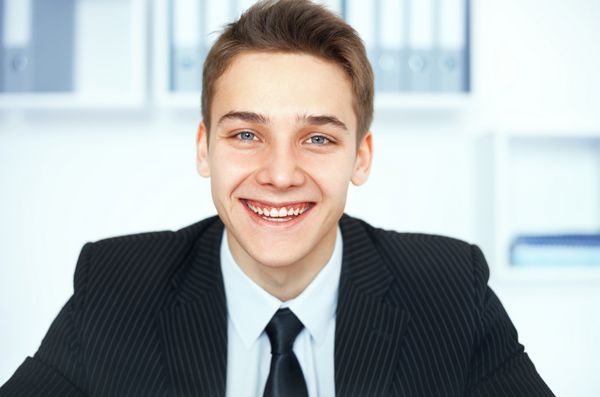 پرتره تاجر جوان در حال خندیدن در دفتر روشن