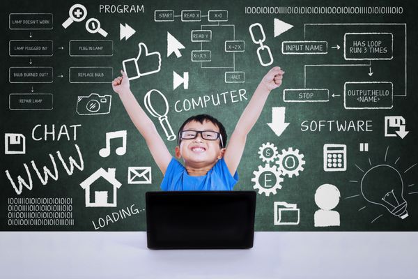 پسر گیک خوشحال برنده مسابقه علوم کامپیوتر با استفاده از لپ تاپ در کلاس