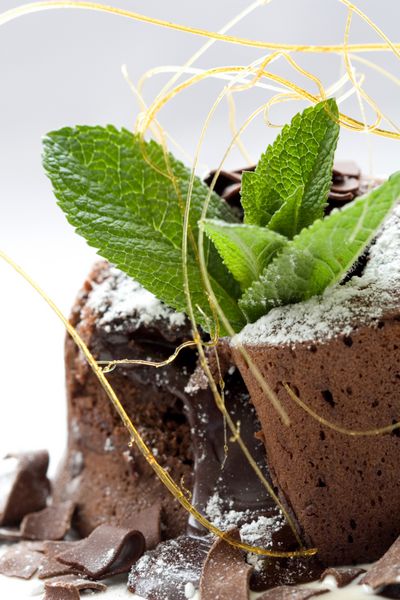 دسر شکلاتی خوشمزه با رشته های شکر سوخته و برگ نعنا تزئین شده است