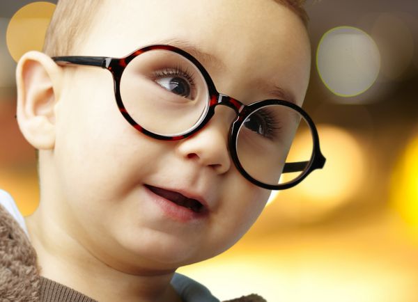 پرتره کودکی با عینک گرد در پس زمینه ای انتزاعی