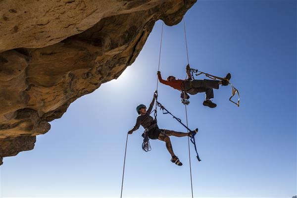 تیم کوهنوردی برای رسیدن به قله یک کوه سنگی چالش برانگیز تلاش می کند