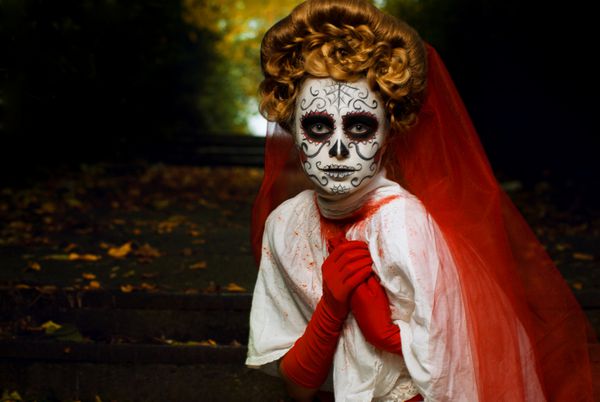 زن جوان در هنر چهره جمجمه ماسک روز مرده هنر چهره هالووین
